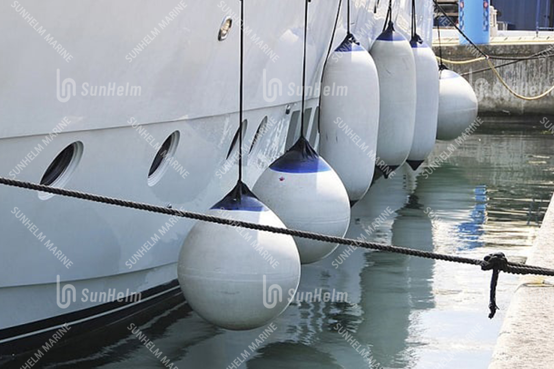 Weiße Fender, die zum Schutz zwischen einem Boot und dem Hafenbecken  aufgehängt werden. Maritime Fender - ein lizenzfreies Stock Foto von  Photocase